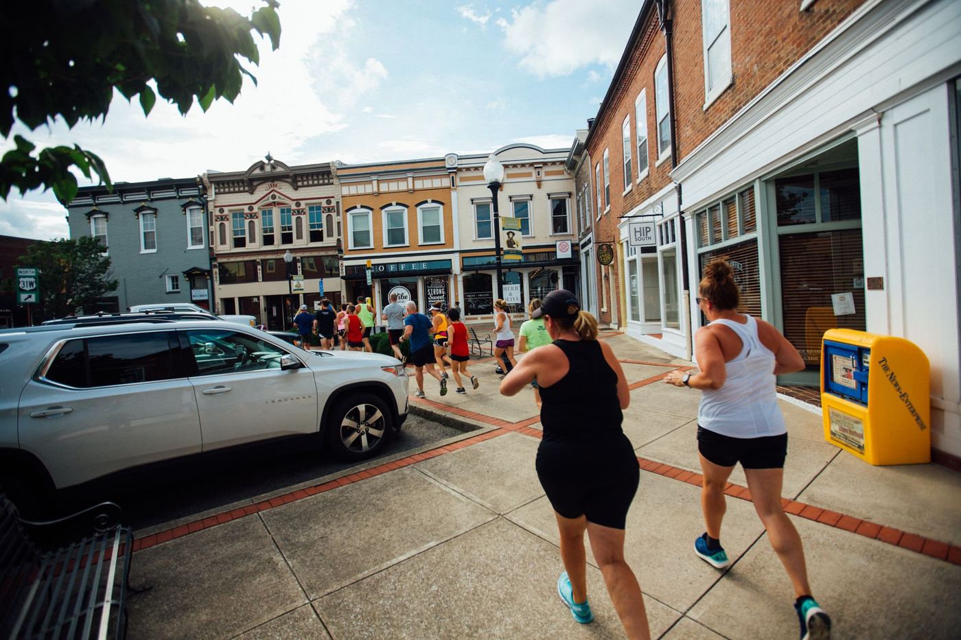 Two runners on a downtown sidewalk during a group run