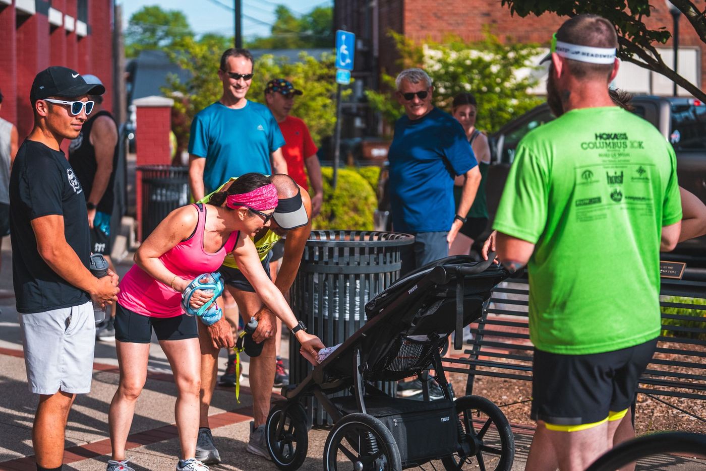 Runners and a parent with a jogging stroller getting ready for a group run